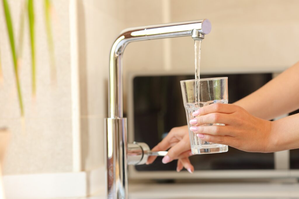 Person filling a glass of tap water